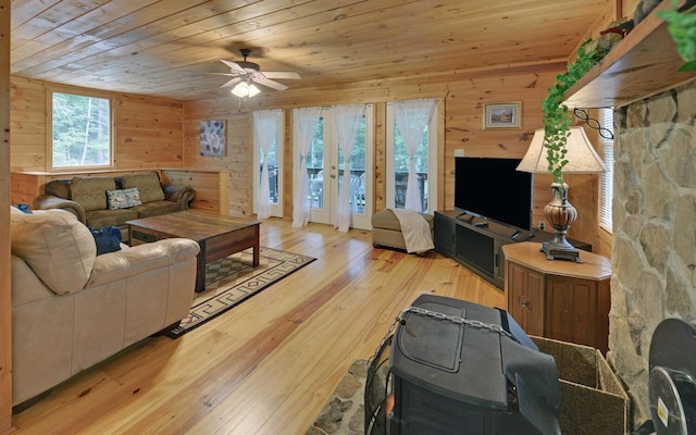 living room featuring french doors, wooden walls, wood ceiling, and light hardwood / wood-style flooring