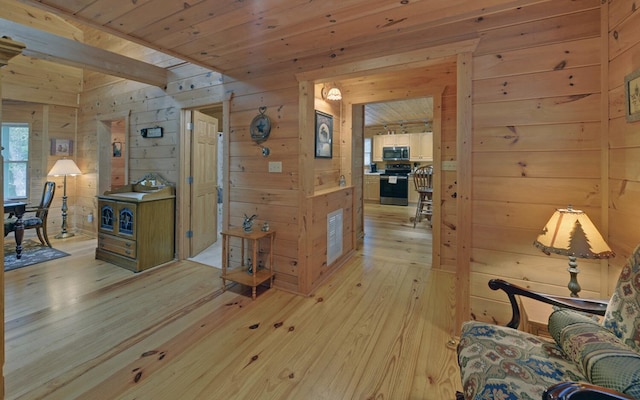 hall with wood ceiling, wood walls, and light wood-type flooring