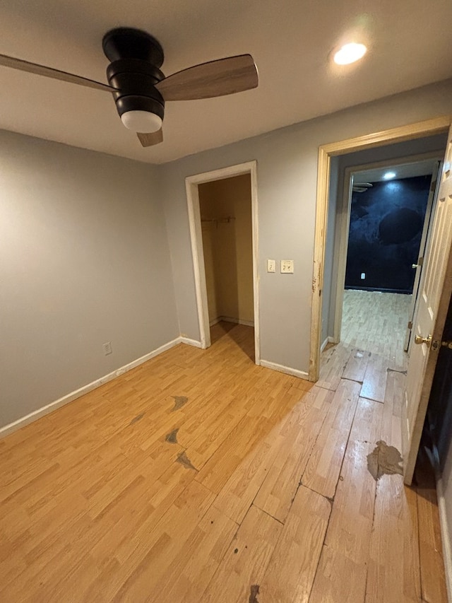 unfurnished room featuring baseboards, light wood-style floors, and a ceiling fan