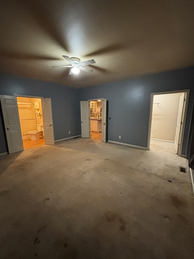 unfurnished bedroom featuring ensuite bath, visible vents, and light carpet