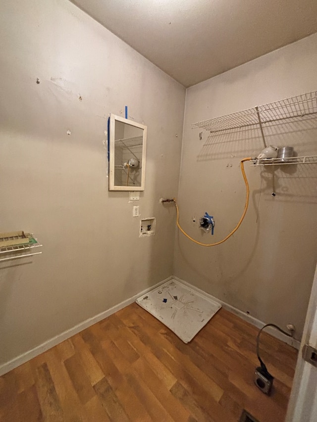 clothes washing area featuring laundry area, hookup for a washing machine, wood finished floors, and baseboards