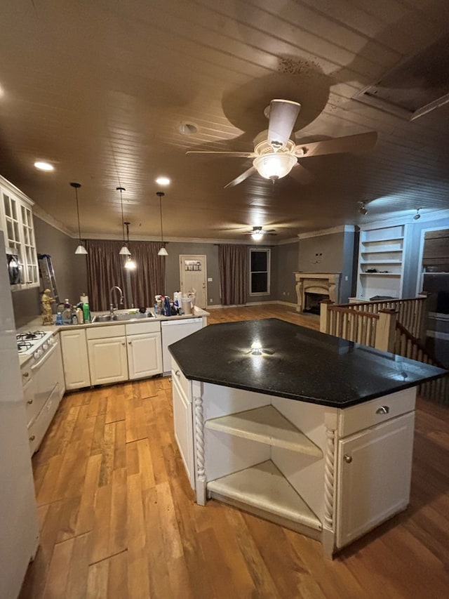 kitchen with light wood-style flooring, a sink, open shelves, a peninsula, and white cabinets