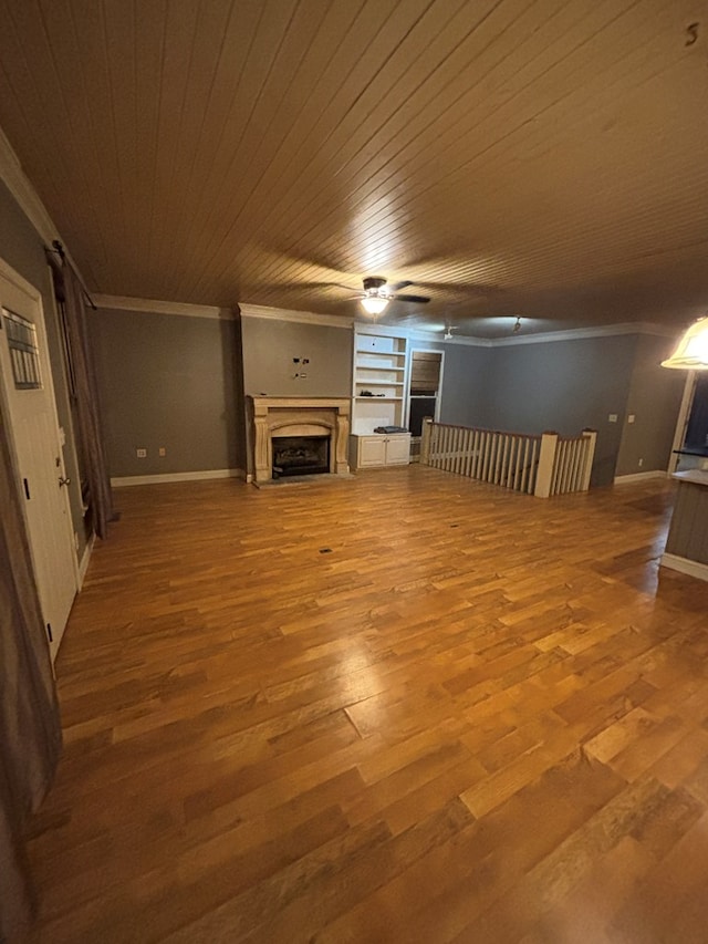 unfurnished living room with wood finished floors, ornamental molding, and a fireplace