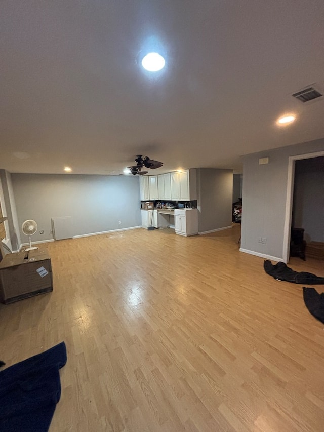 unfurnished living room featuring light wood finished floors, visible vents, and baseboards