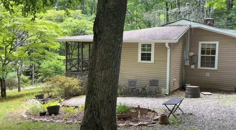 66 Patterson Ln, Hayesville, NC 28904 - view of home's exterior featuring roof with shingles and a sunroom