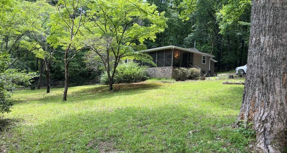66 Patterson Ln, Hayesville, NC 28904 - view of green lawn featuring a sunroom and a wooded view