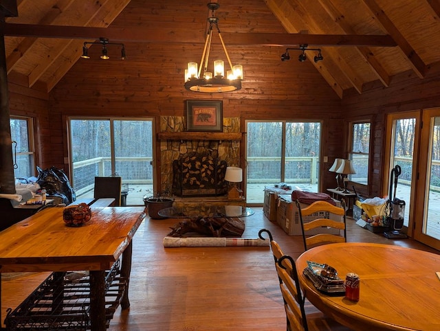 dining room featuring wood-type flooring, wood ceiling, beamed ceiling, and a healthy amount of sunlight