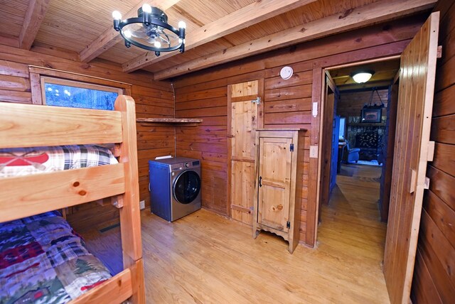 bedroom with beam ceiling, wood ceiling, light wood-type flooring, and wood walls