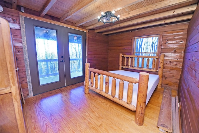 bedroom featuring wood ceiling, wooden walls, light hardwood / wood-style floors, french doors, and beamed ceiling