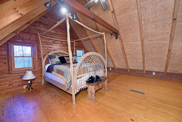 bedroom with hardwood / wood-style flooring, ceiling fan, vaulted ceiling with beams, wooden walls, and wooden ceiling