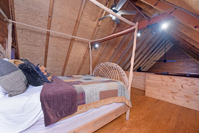 bedroom with hardwood / wood-style floors, vaulted ceiling, and ceiling fan