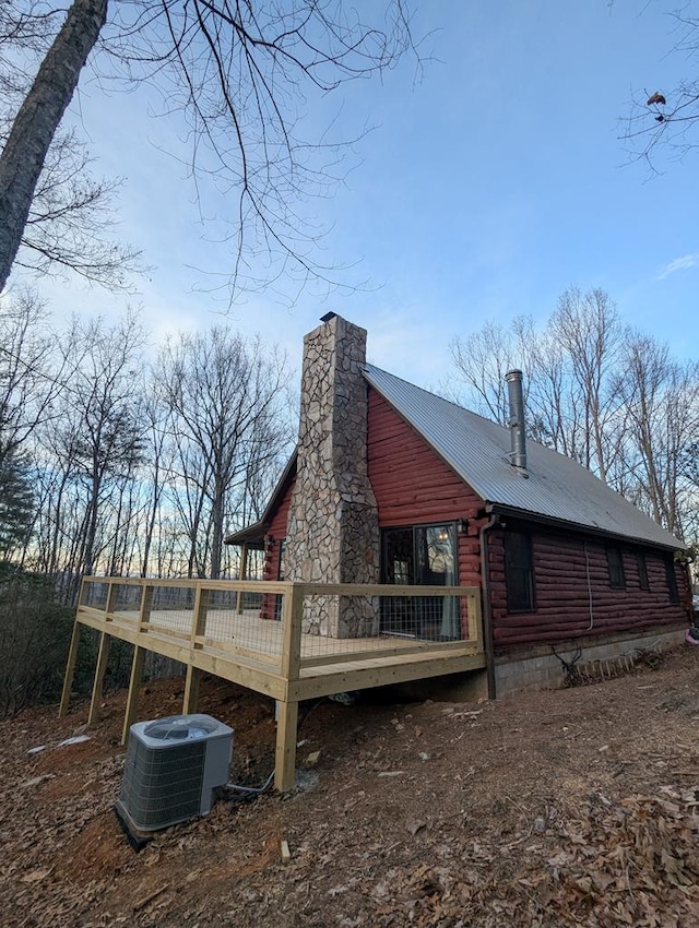 view of side of property featuring central AC unit and a wooden deck