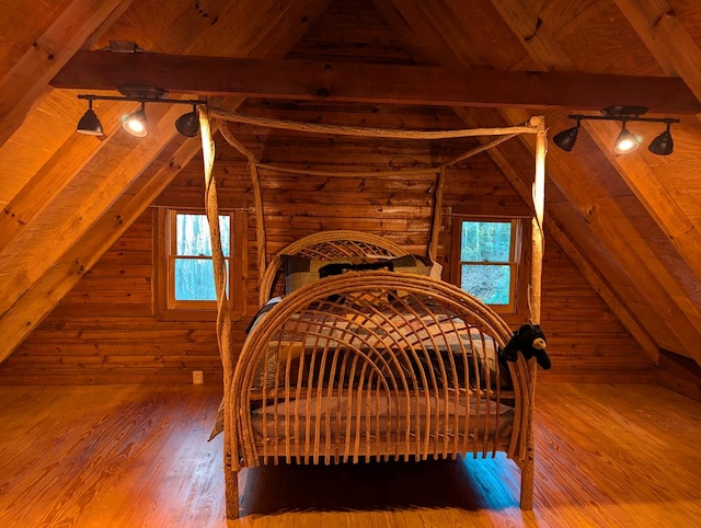 bedroom with wood ceiling, wood-type flooring, rustic walls, and vaulted ceiling with beams