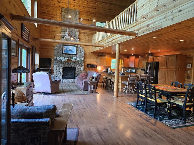1102 Summit Way, Blairsville, GA 30512 - living area featuring a towering ceiling, light wood-style flooring, wooden walls, and a stone fireplace