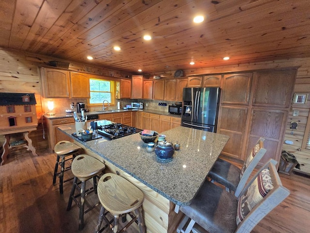 1102 Summit Way, Blairsville, GA 30512 - kitchen with black appliances, a sink, wood finished floors, light stone counters, and a kitchen breakfast bar