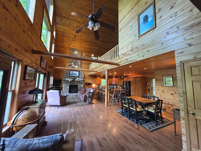 1102 Summit Way, Blairsville, GA 30512 - dining space with a towering ceiling, wooden walls, ceiling fan, wood finished floors, and a fireplace