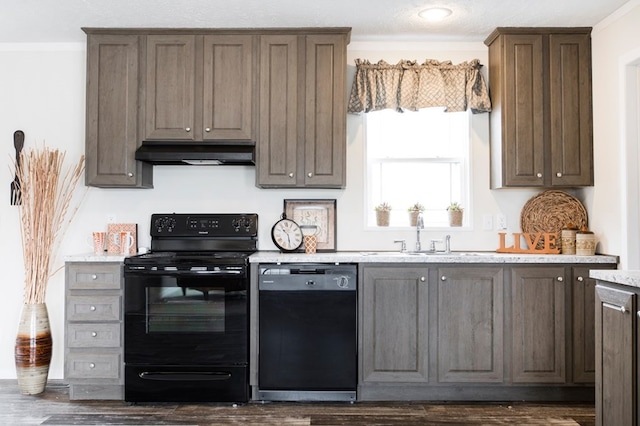 kitchen featuring crown molding, a sink, black appliances, dark wood-style floors, and under cabinet range hood