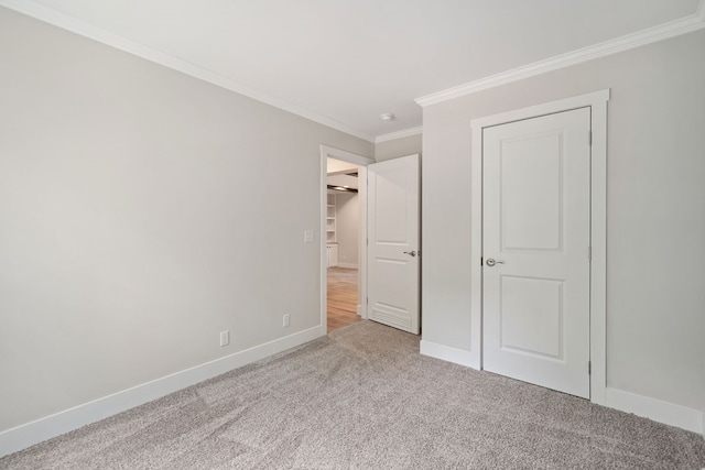 unfurnished bedroom with carpet floors, baseboards, and crown molding