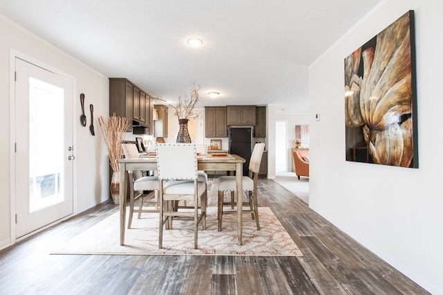 dining area with baseboards, ornamental molding, wood finished floors, and a wealth of natural light