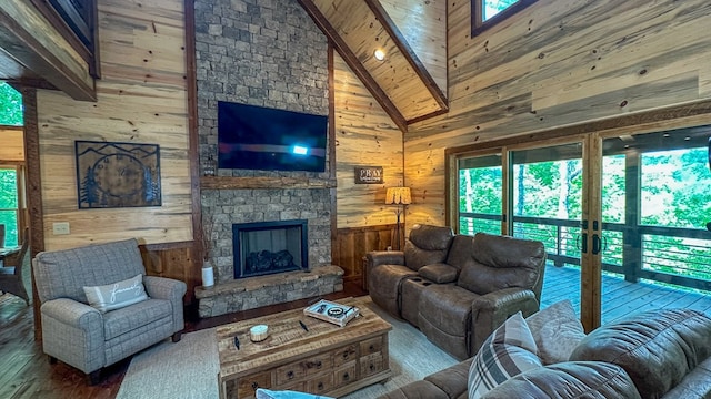 340 Hooch Holler Ln, Morganton, GA 30560 - living room with wood walls, hardwood / wood-style flooring, healthy amount of natural light, a stone fireplace, and beamed ceiling