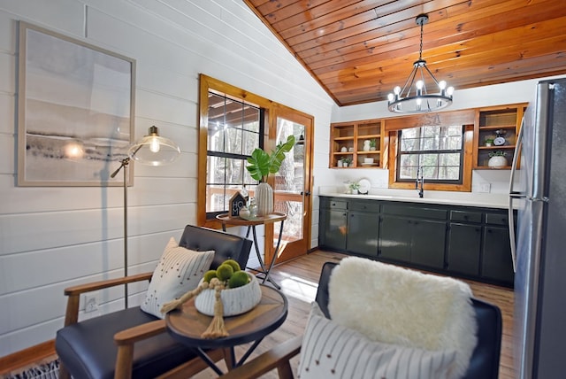 kitchen with wood ceiling, a wealth of natural light, lofted ceiling, and stainless steel refrigerator