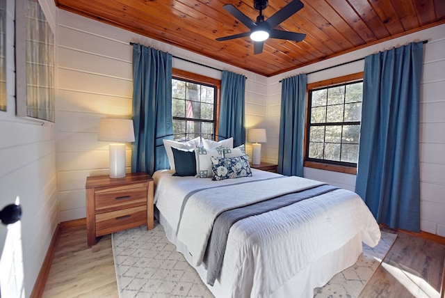 bedroom featuring light hardwood / wood-style floors, multiple windows, wooden ceiling, and ceiling fan