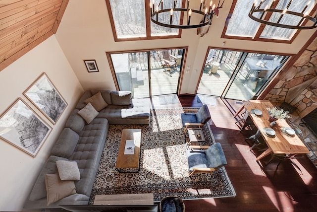 living room featuring wood finished floors, a towering ceiling, and a notable chandelier