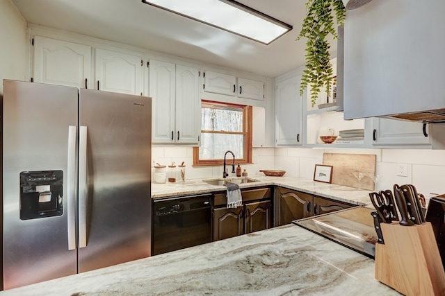 kitchen featuring black dishwasher, stainless steel fridge, white cabinets, and a sink