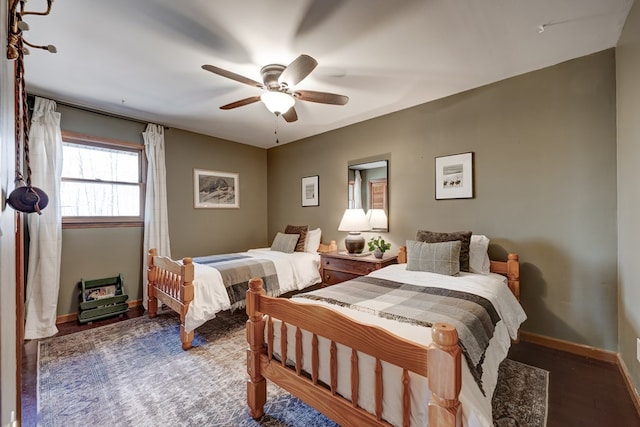 bedroom with ceiling fan, baseboards, and wood finished floors