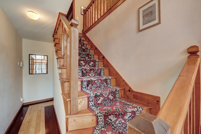 staircase featuring wood-type flooring and baseboards