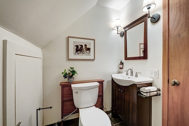 bathroom with toilet, vaulted ceiling, a textured ceiling, and vanity