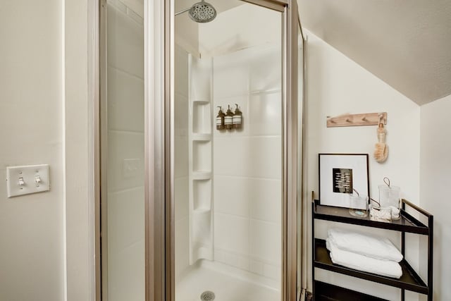 bathroom featuring vaulted ceiling and a stall shower