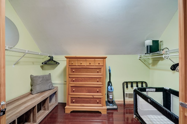 walk in closet with lofted ceiling, dark wood-style flooring, and visible vents