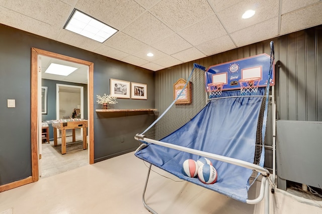 playroom featuring a paneled ceiling, wood walls, and recessed lighting