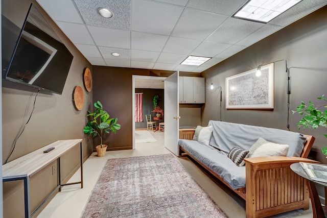 living area featuring a drop ceiling and recessed lighting