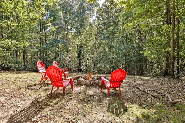 view of yard with a fire pit and a forest view