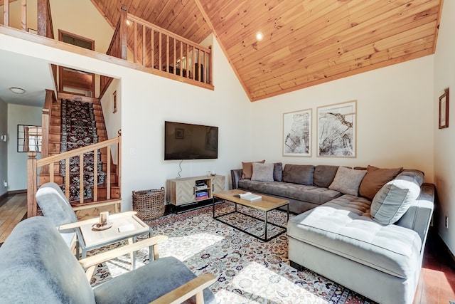 living area with baseboards, wood ceiling, wood finished floors, stairs, and high vaulted ceiling