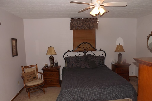 carpeted bedroom featuring a textured ceiling and ceiling fan