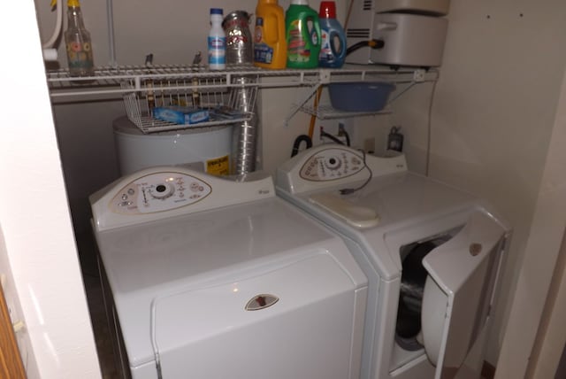 clothes washing area featuring washing machine and dryer and water heater