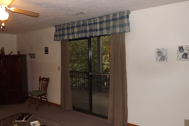 living room featuring carpet, ceiling fan, and a textured ceiling