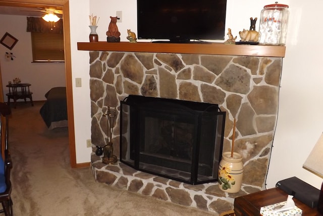 details featuring a stone fireplace, ceiling fan, and carpet flooring