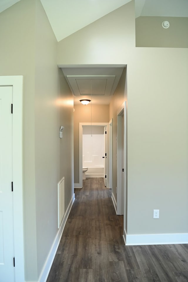 hall with vaulted ceiling and dark hardwood / wood-style flooring