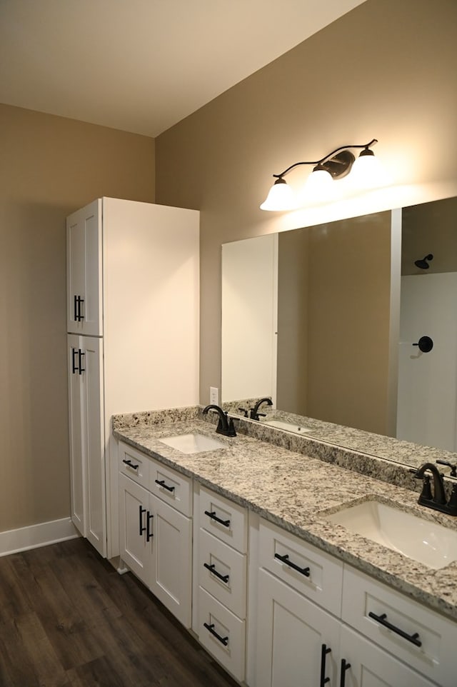 bathroom with dual sinks, wood-type flooring, and large vanity