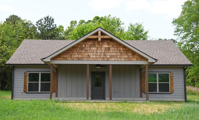 rear view of house featuring ceiling fan and a lawn