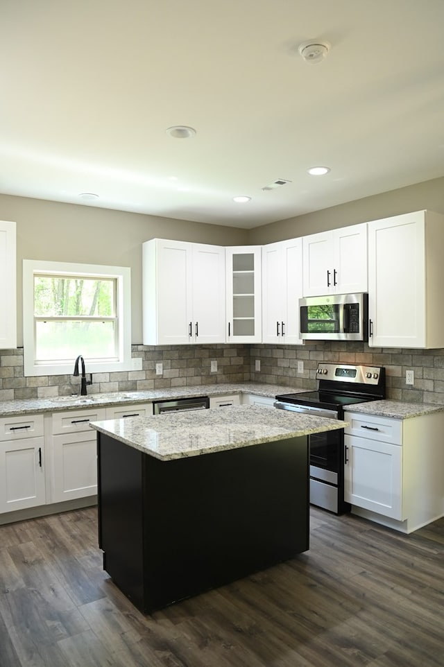 kitchen with white cabinets, tasteful backsplash, stainless steel appliances, and dark wood-type flooring