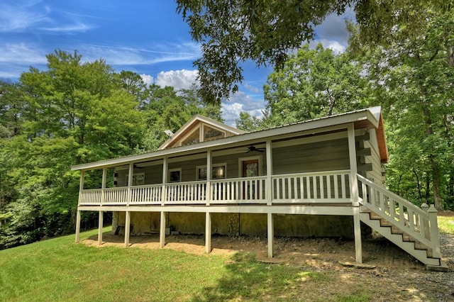 view of front facade with stairway, metal roof, and a front lawn