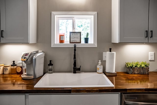 kitchen featuring wood counters, gray cabinets, sink, and dishwasher