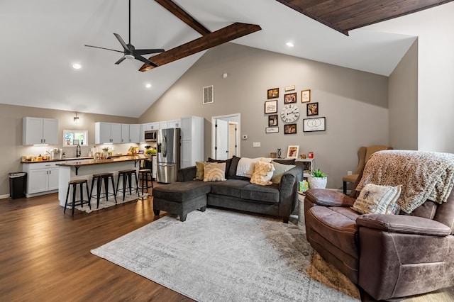 living room featuring dark hardwood / wood-style floors, ceiling fan, beam ceiling, and high vaulted ceiling