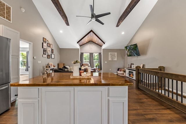 kitchen with butcher block countertops, stainless steel refrigerator, white cabinets, and a kitchen island