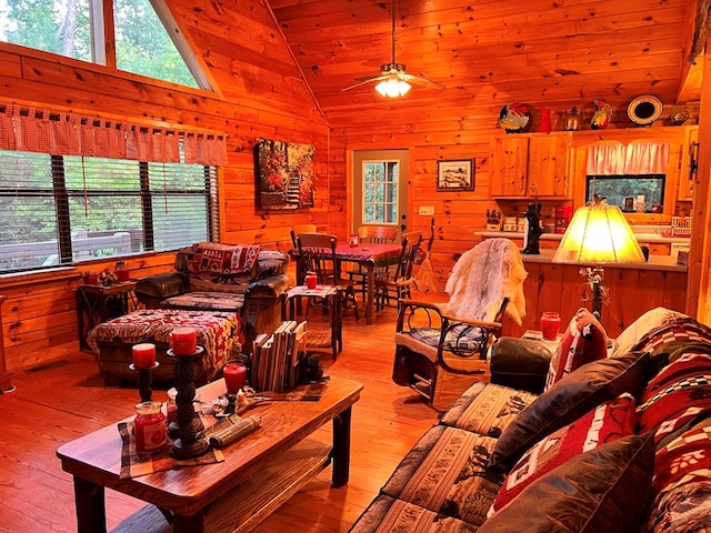 living room featuring wooden ceiling, ceiling fan, high vaulted ceiling, light hardwood / wood-style flooring, and wooden walls